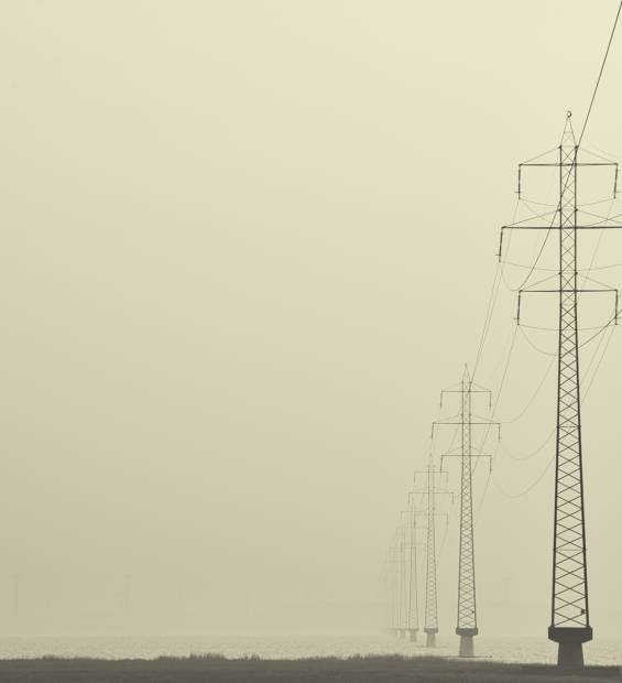 A foggy shot of transmission towers in the middle of a street